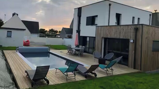 A modern house with a swimming pool, outdoor seating, and a large garage. - Seaside villa PMR standard Portsall (Ploudalmézeau)