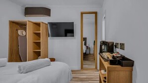 A hotel room with a bed, a wooden wardrobe, a television, a desk with a coffee machine, and a mirror. - Downs View a Tranquil Space for Two - Pass the Keys (Chartham)