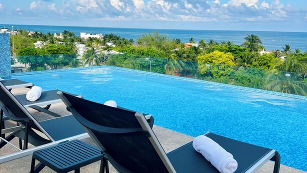 A poolside area with lounge chairs and a view of the ocean. - Areia Boutique Hotel - Puerto Morelos (Puerto Morelos)