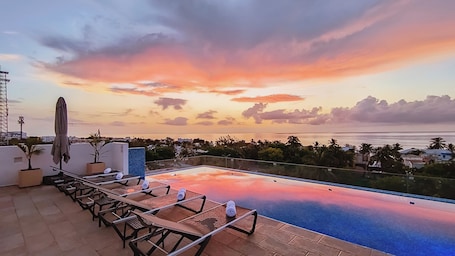 Una piscina al aire libre, camas de piscina gratis, sombrillas