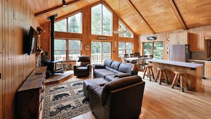 A spacious cabin with a large living area, a fireplace, and a kitchen. - Lakefront Cabin w/ Pool Table+Waterfall: Northwoods Nostalgia + Modern Amenities (Clam Lake)