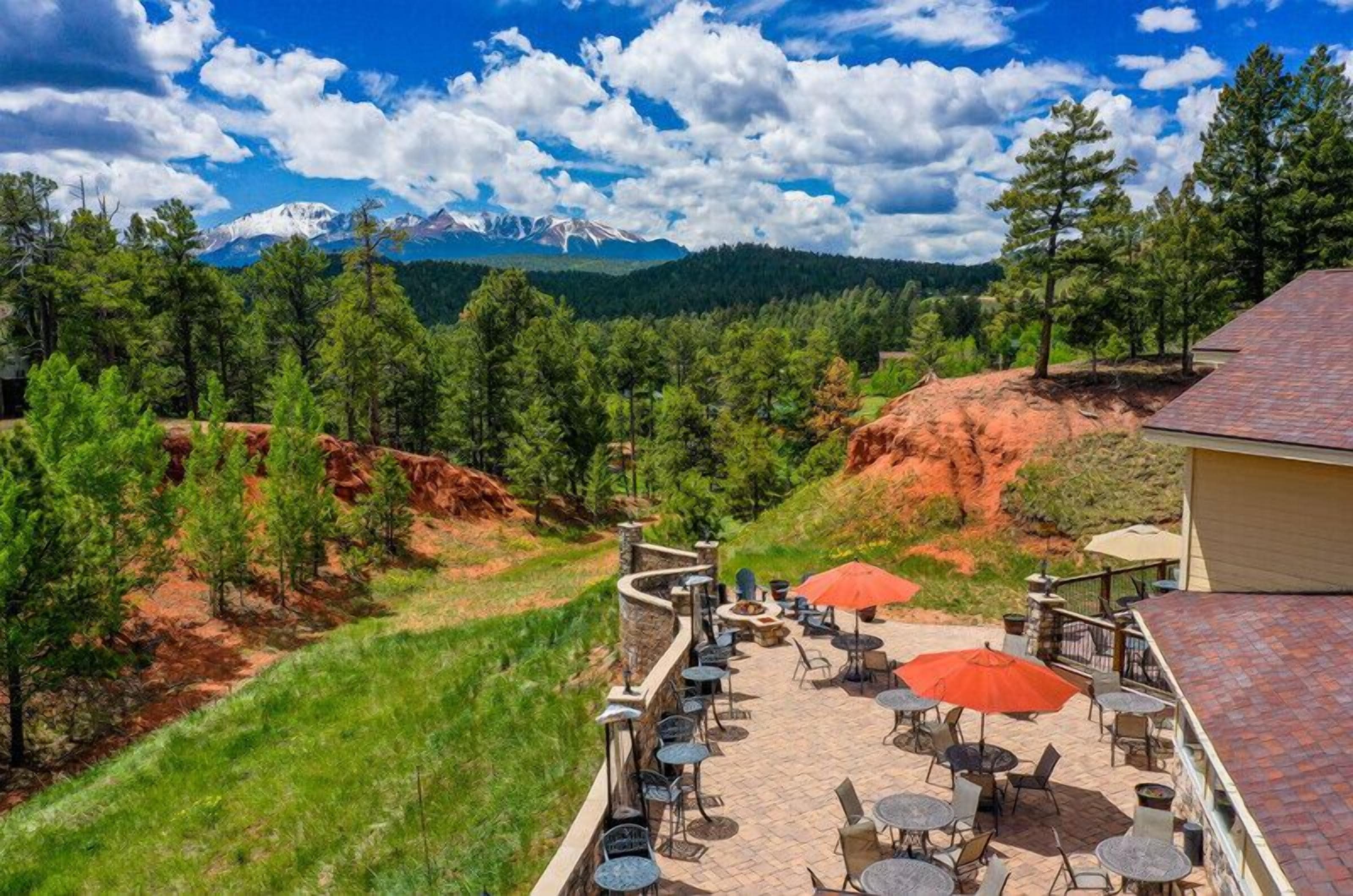 A patio with outdoor seating and a view of a mountainous landscape.