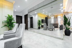 A modern lobby with a seating area, a large mirror, and potted plants. - The Azaria Hotel & Apartments (Lekki)