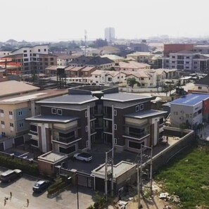 A residential area with modern multi-story buildings, a parking lot, and a clear view of the surrounding neighborhood. - The Azaria Hotel & Apartments (Lekki)