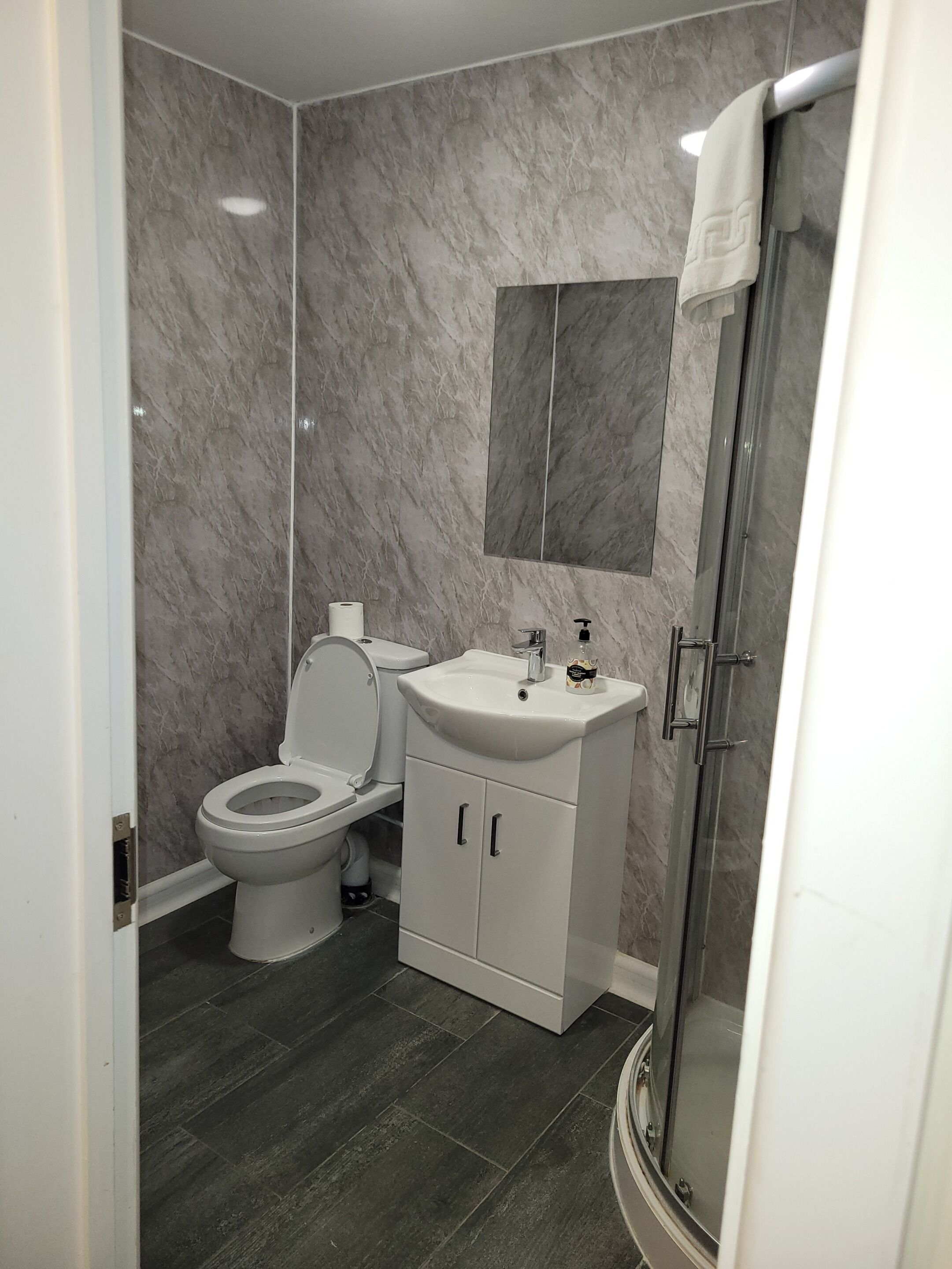 A modern bathroom with a toilet, sink, and shower.