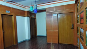 Hall d'albergo con porte in legno, con i numeri 601 e 603, e un soffitto con illuminazione a incasso.
