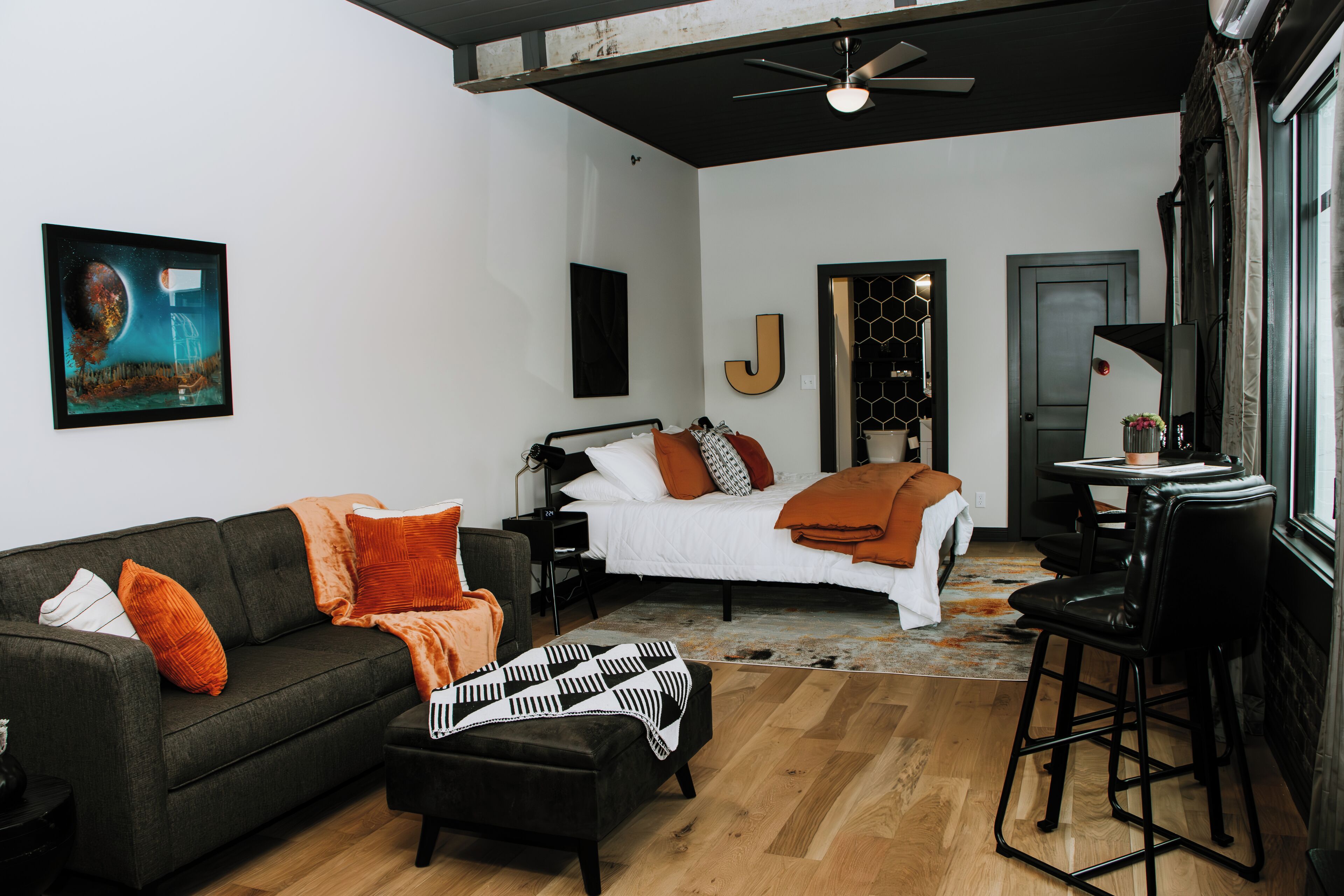 Un dormitorio moderno con cama, sofá y escritorio.