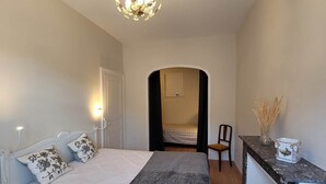 A bedroom with a bed, bedside lamps, a desk, and a chandelier. - Gentiane *** 5 people (Bagnères-de-Luchon)