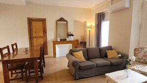 A living room with a wooden dining table, a sofa, and a coffee table. - Gentiane *** 5 people (Bagnères-de-Luchon)