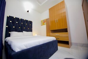 Un dormitorio con una cama, un armario de madera y una lámpara en el techo.