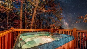 A hot tub on a wooden deck with a night sky and stars. - Smoky Mtn Cabin | Hot Tub | Sleep 12 | Pets | View (Gatlinburg)