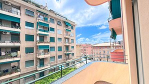 Un immeuble résidentiel à plusieurs étages, doté de balcons, d’un auvent vert et surplombant un ciel dégagé.