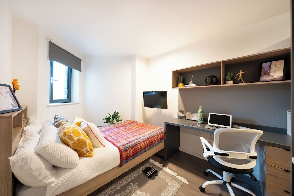 A modern bedroom with a bed, desk, and chair.