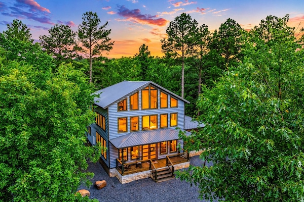 Exterior Oasis: Stunning architecture with vibrant sunset views amid lush greenery awaits you!