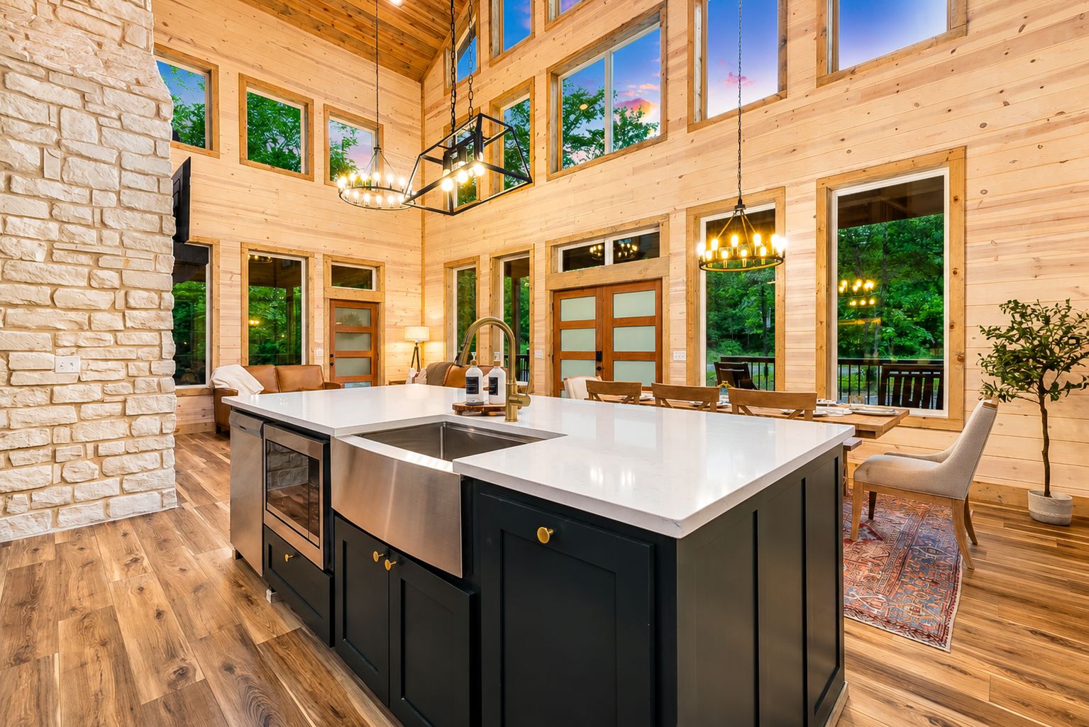 A spacious kitchen with a large island, wooden cabinetry, and a stone accent wall.