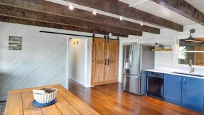 A modern kitchen with wooden cabinets, a built-in dishwasher, and a large island with a bowl.