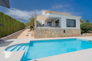 A modern house with a stone facade, a pool, and a patio area with outdoor furniture. - CostaBlancaDreams - Casa Sereno in Calpe (Calpe / Calp)
