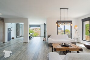 A modern interior with a bed, a dining table, and a view of the outdoors. - CostaBlancaDreams - Casa Sereno in Calpe (Calpe / Calp)