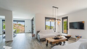 A modern living room with a sofa, a coffee table, and a TV mounted on the wall. - CostaBlancaDreams - Casa Sereno in Calpe (Calpe / Calp)