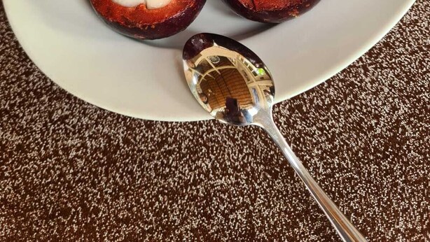 Ein Teller mit kandierten Süßkartoffeln und einem Löffel.