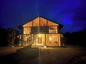 A two-story building with a flat roof and large windows, surrounded by trees. - The Sanctuary (Wanathavilluwa)