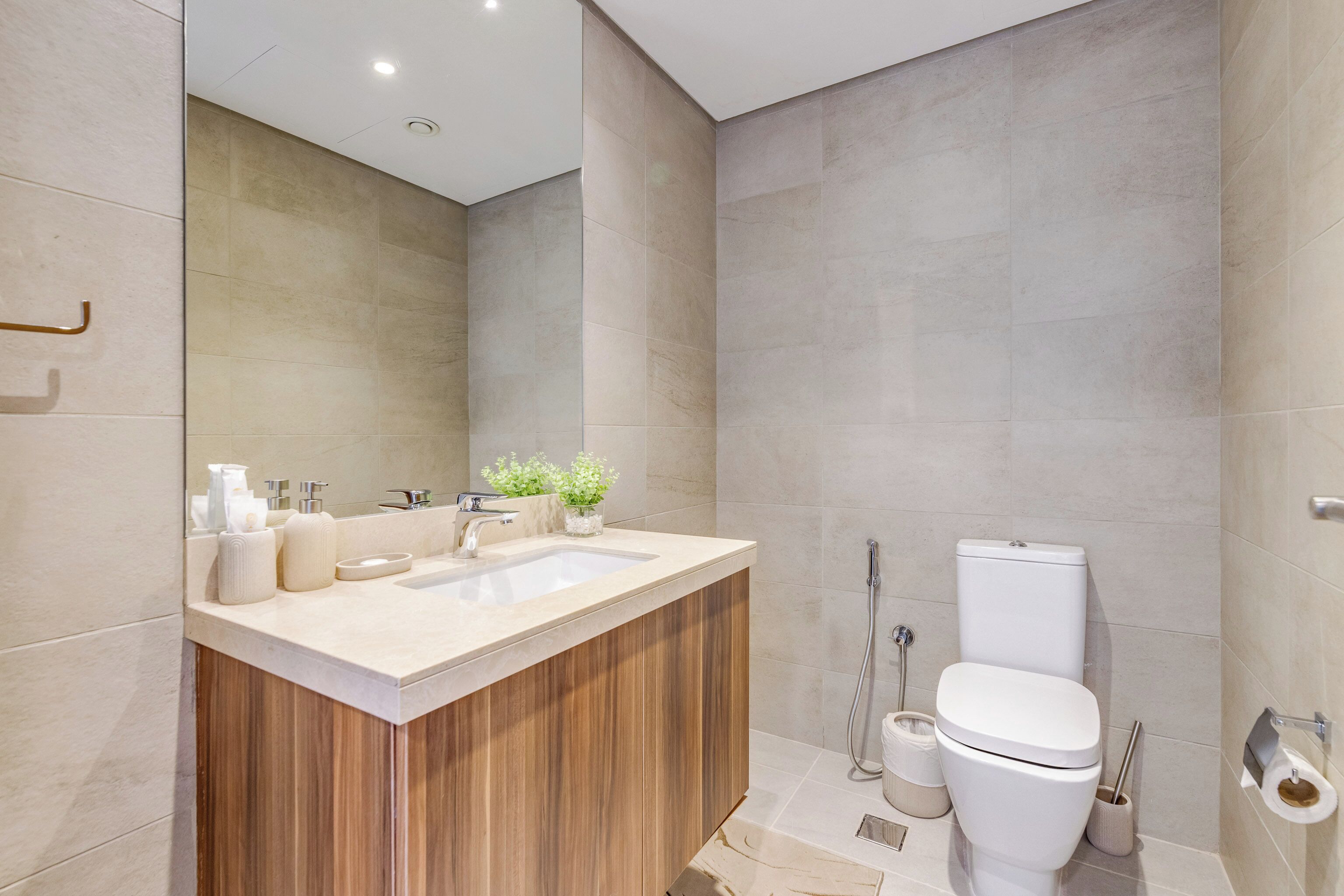 A modern bathroom with a wooden vanity, a sink, and a toilet.