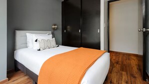Ein Schlafzimmer mit Bett, Kleiderschrank und Fernseher.