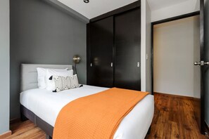 Ein Schlafzimmer mit Bett, Kleiderschrank und Fernseher.