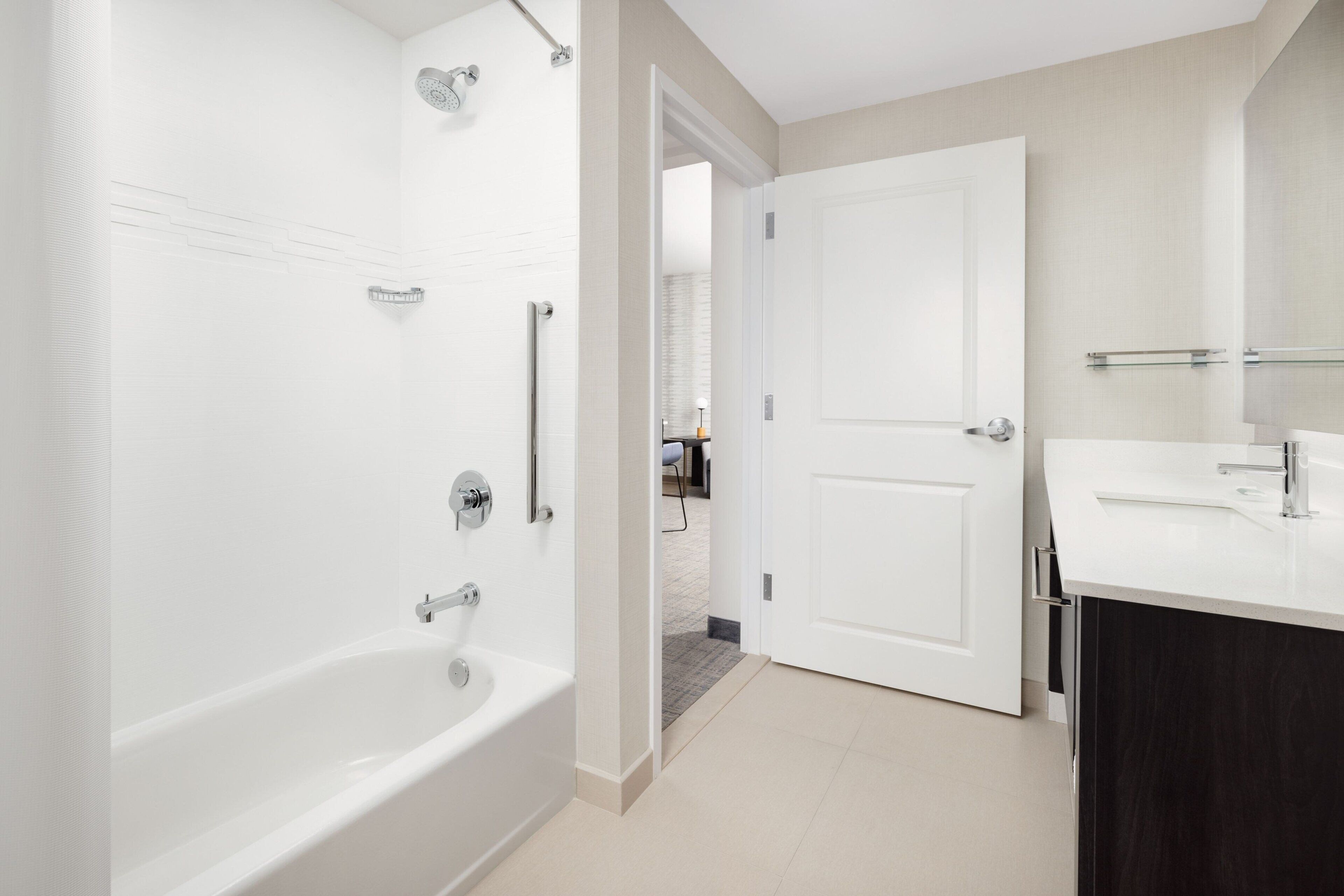Un baño moderno con bañera, ducha y tocador con espejo.