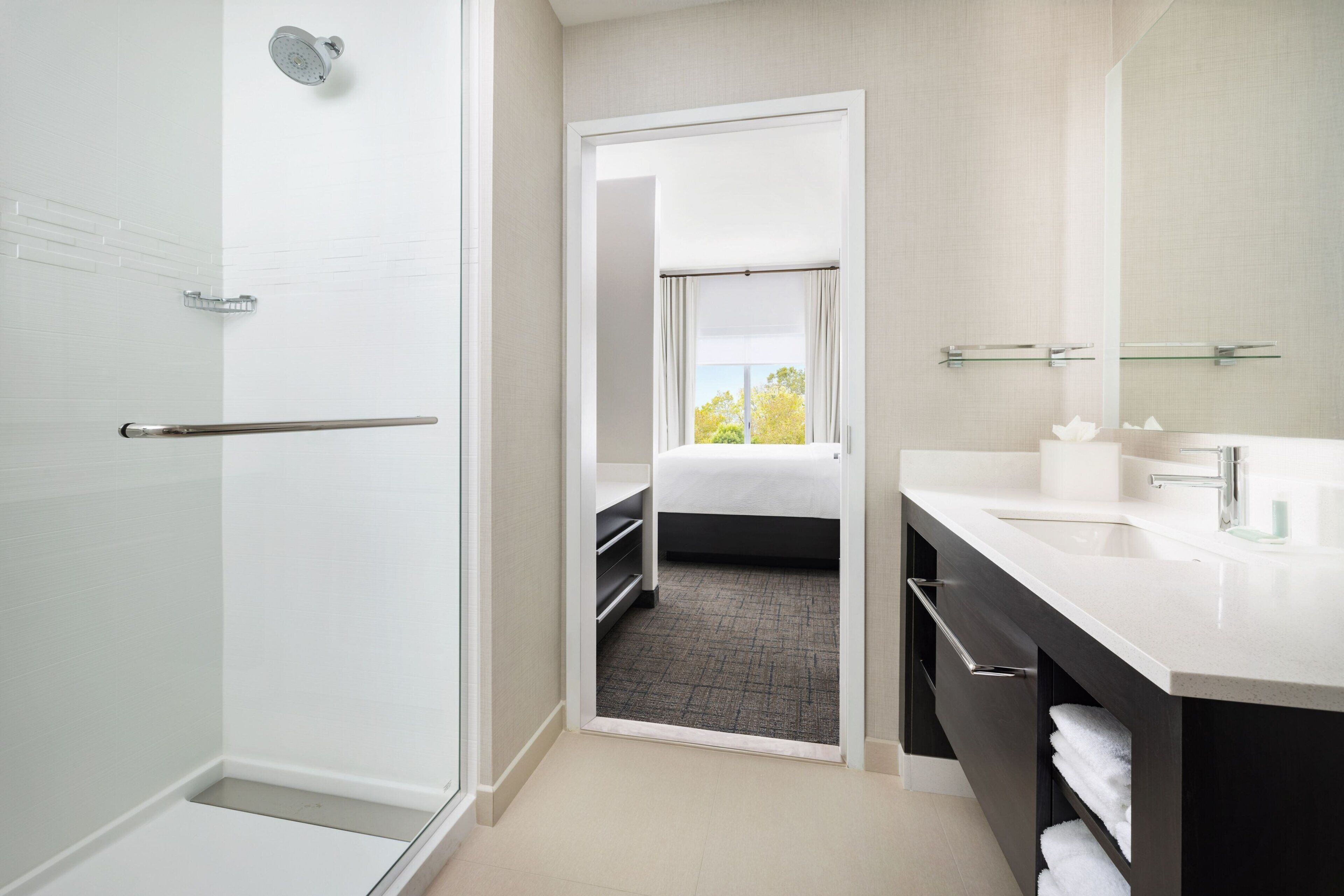 A modern bathroom with a shower, a sink, and a mirror.