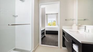 A modern bathroom with a shower, a sink, and a mirror.