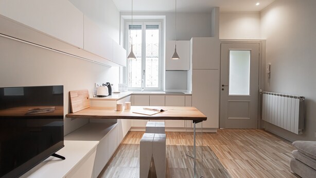 Une cuisine moderne dotée d’un plan de travail en bois, d’un four encastré et d’une fenêtre offrant une belle vue.
