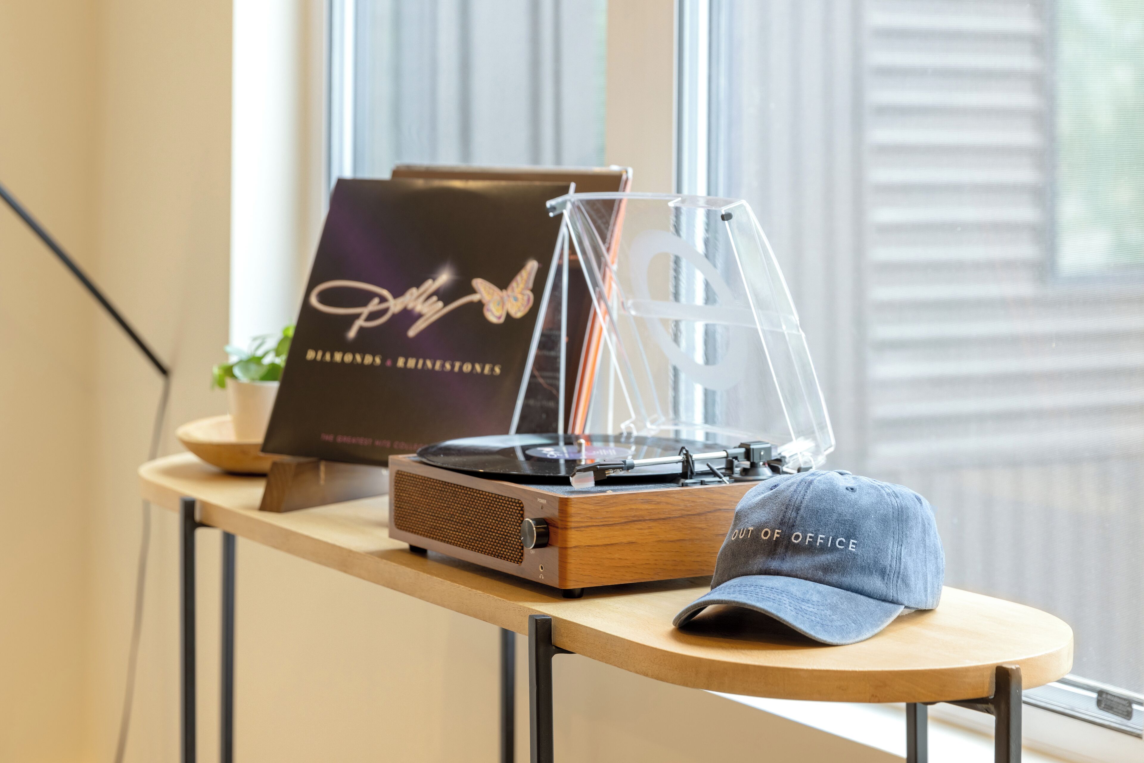 A wooden table with a turntable, a framed certificate, and a cap.