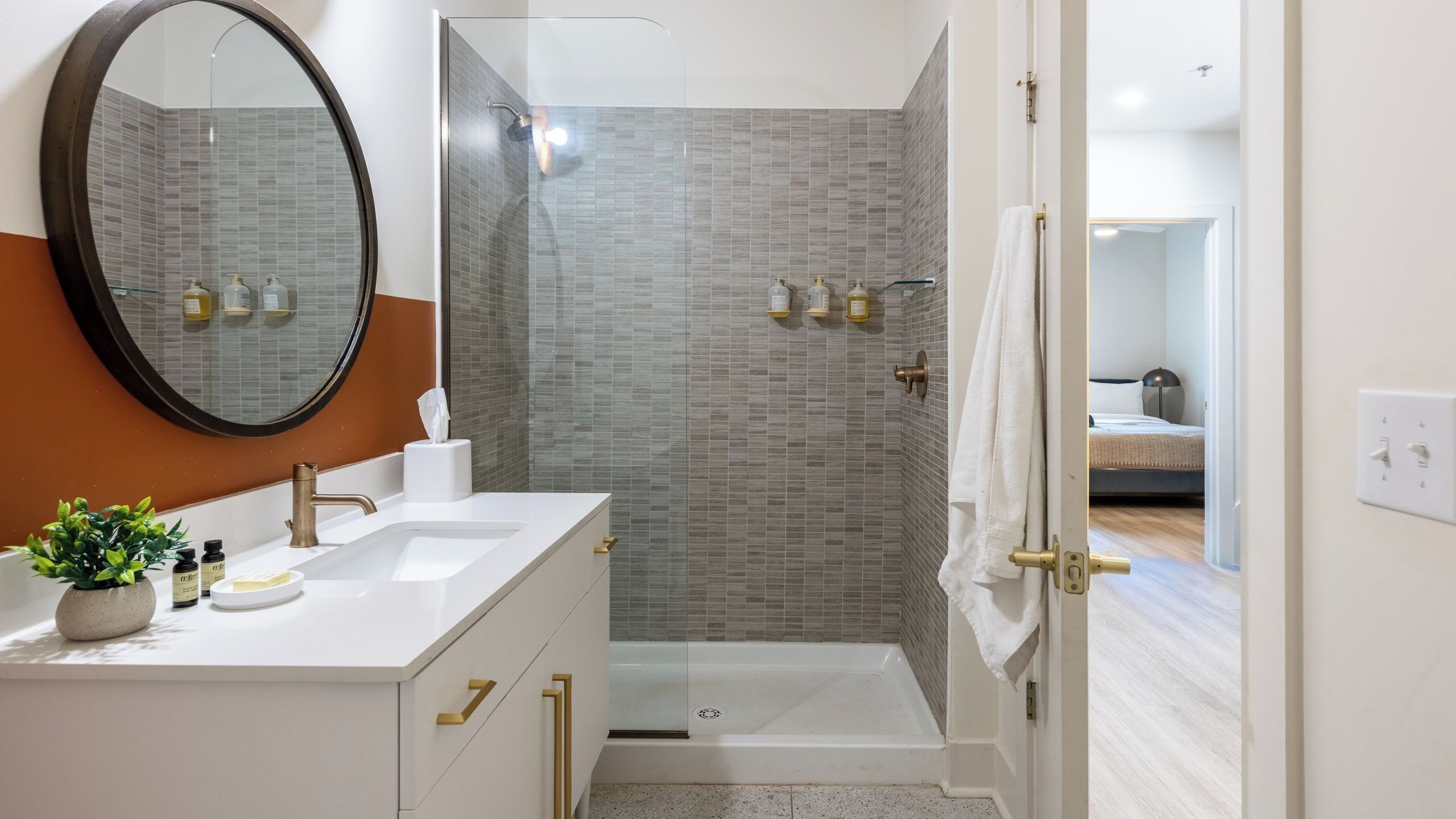 Un baño moderno con un espejo grande, dos lavamanos, una ducha y un inodoro.