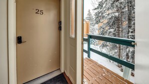 Eine Tür mit der Nummer 25, einem Metall-Briefschlitz und einem Holzboden mit Schnee.