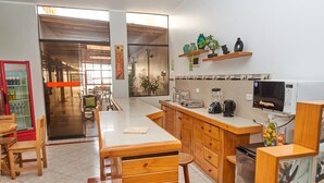 Una cocina moderna con armarios de madera, microondas integrado y cafetera.