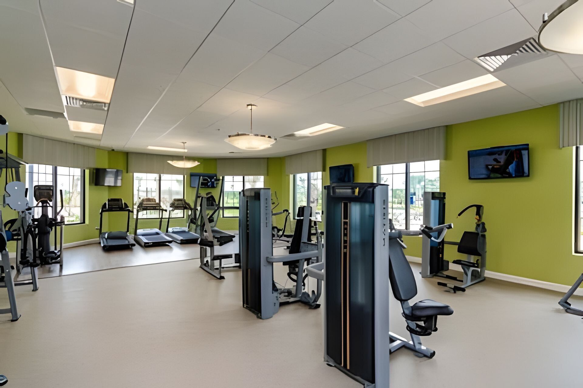 Ein Fitnessstudio mit Laufbändern, Kraftgeräten und Trainingsausrüstung.