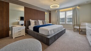 Um quarto moderno com uma cama grande, uma cômoda, uma penteadeira e um candelabro.