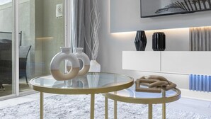 A modern interior with two round glass tables, white and black vases, and a white cabinet against a wall with a framed picture. - Comfortable 5BR Home Near Disney 10 min (Kissimmee)