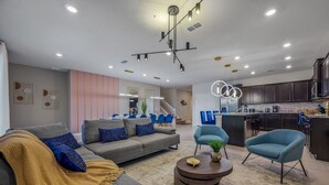 A modern living room with a grey sofa, blue armchairs, and a coffee table.