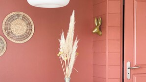 Une table à manger dressée avec des assiettes, des verres et un vase contenant des plantes séchées.