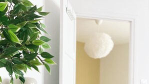 Une chambre moderne équipée d’un bureau, d’une chaise, d’un lit et d’un luminaire suspendu.