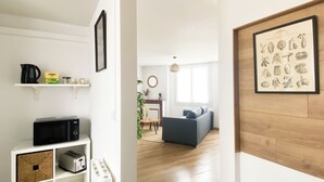 Un appartement moderne comprenant un coin cuisine, un salon avec un canapé et une table à manger, et un plancher en bois.