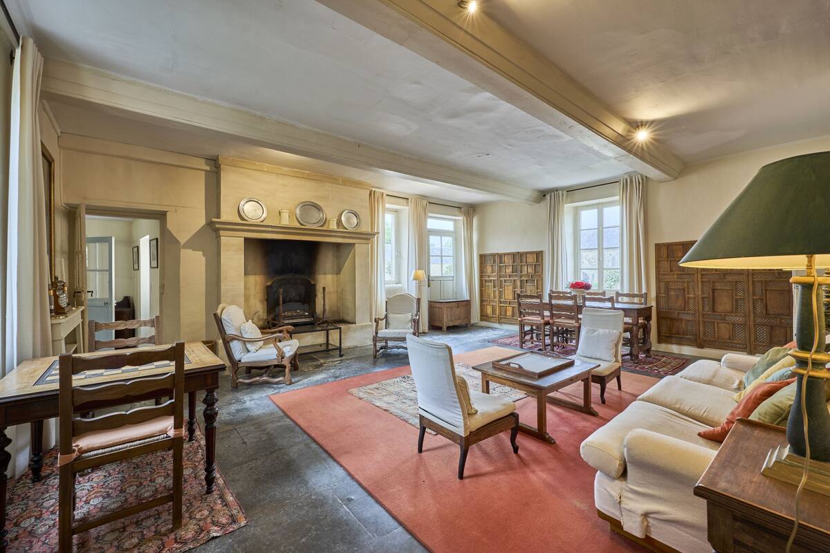 Un salon spacieux avec une cheminée, un coin repas et un espace salon confortable.