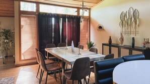 A dining area with a wooden table, chairs, and a ceiling with exposed beams. - Superhome Riverbottoms Home in Bismarck (Bismarck)