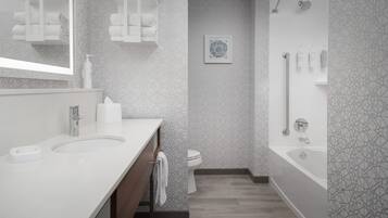 A modern bathroom with a large sink, a toilet, and a shower area.
