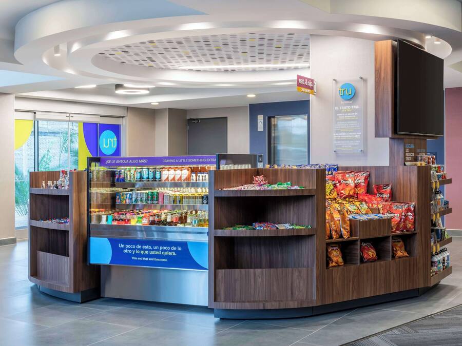 A snack kiosk with a variety of snacks and beverages, a digital screen displaying information, and a sign with the logo 'tru'.