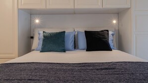 A bed with a white headboard, two side-by-side pillows, and a dark throw blanket. - Il Colibrì by Wonderful Italy (Turin)