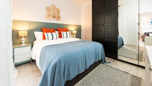 A bedroom with a bed, nightstands, a mirror, and a wardrobe. - Costa del Silencio: Private Terrace & Pool (Arona)