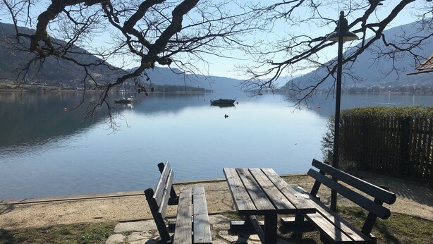 Vistes al llac amb bancs i una superfície d'aigua tranquil·la.